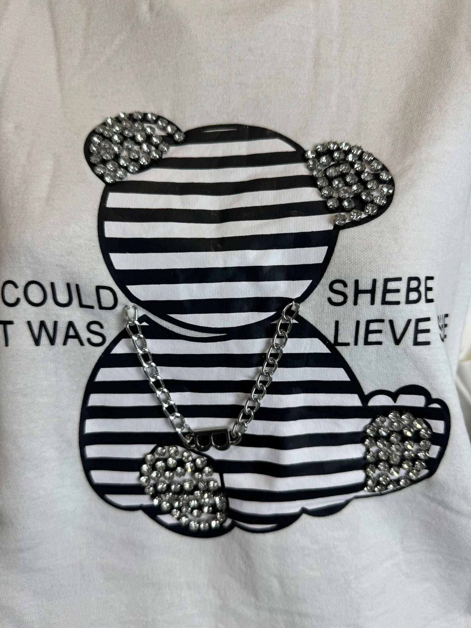 Tricou damă alb cu ursuleț, strasuri și lanț decorativ – model premium modern