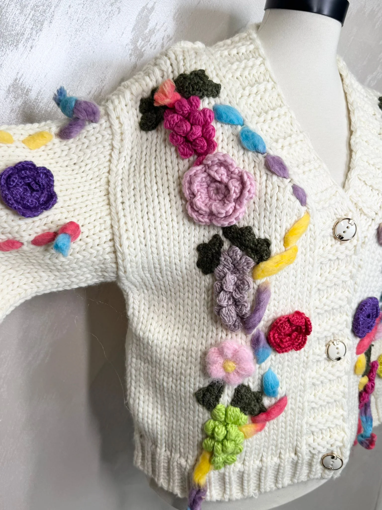 Cardigan croșetat manual în Franța, cu aplicații florale colorate și design unic.