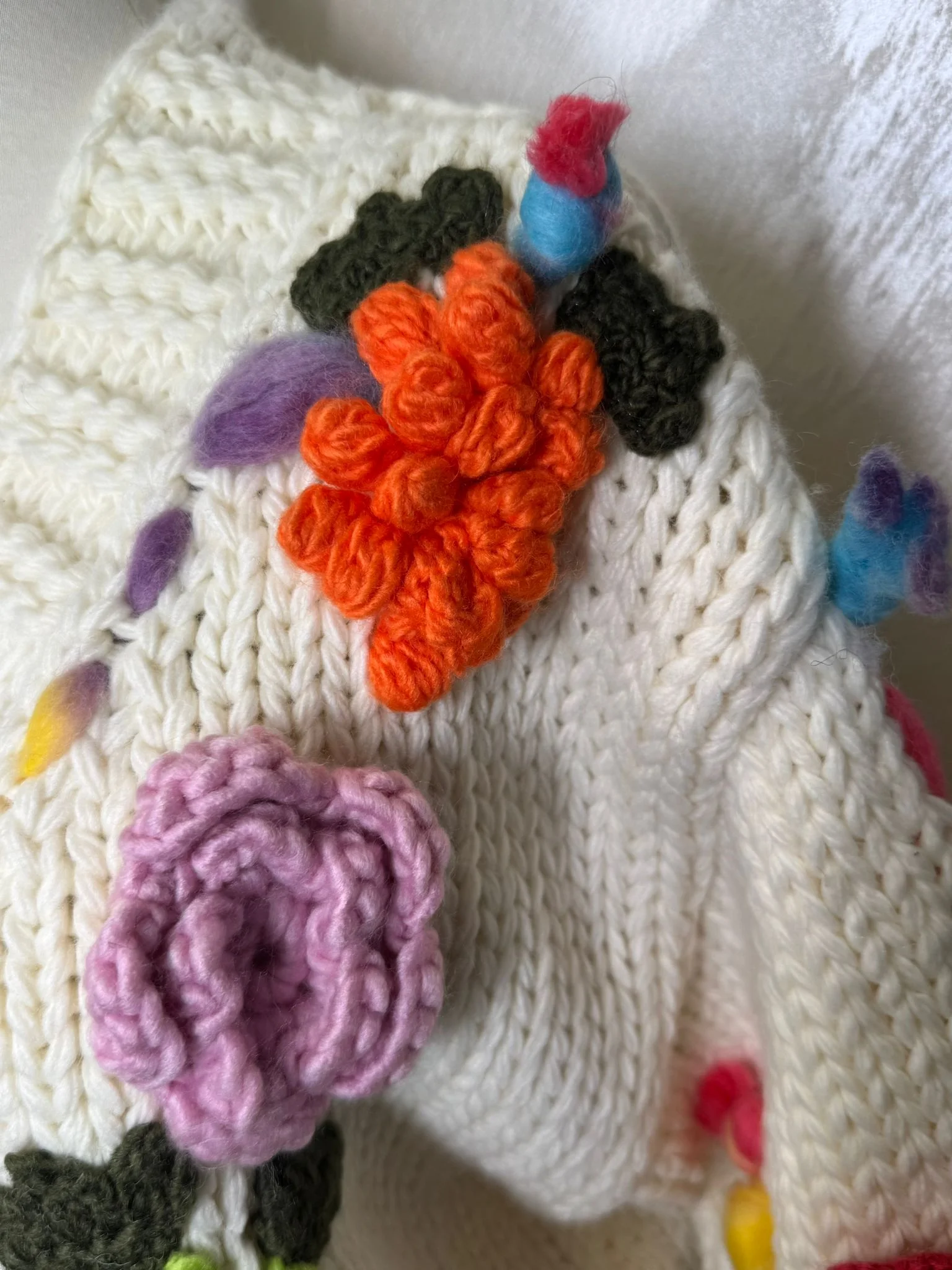 Cardigan croșetat manual în Franța, cu aplicații florale colorate și design unic.