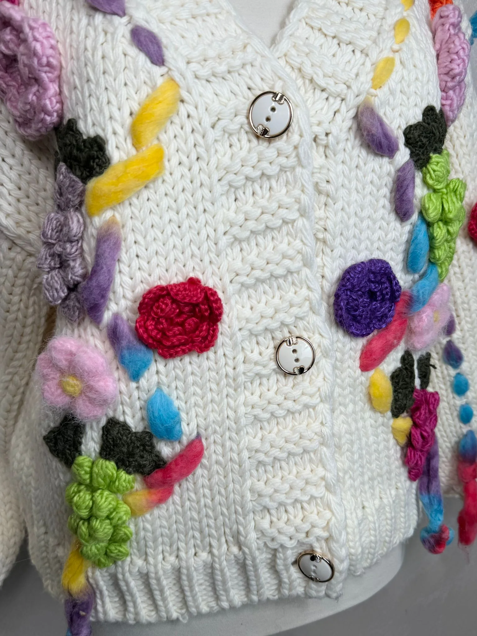 Cardigan croșetat manual în Franța, cu aplicații florale colorate și design unic.