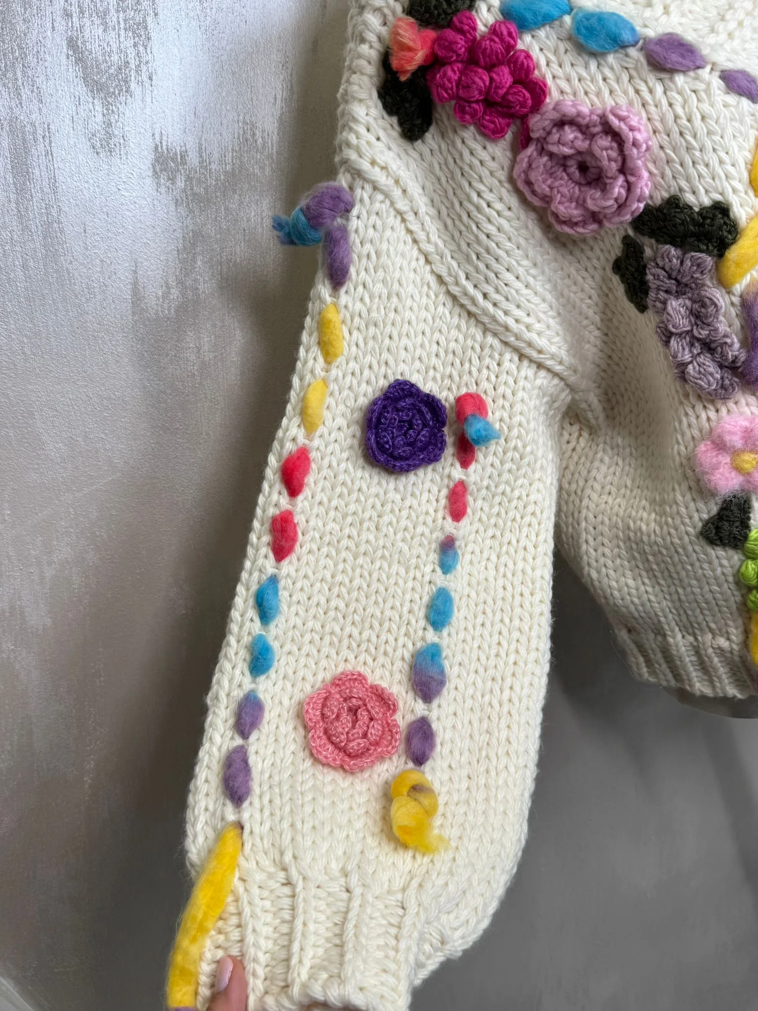 Cardigan croșetat manual în Franța, cu aplicații florale colorate și design unic.